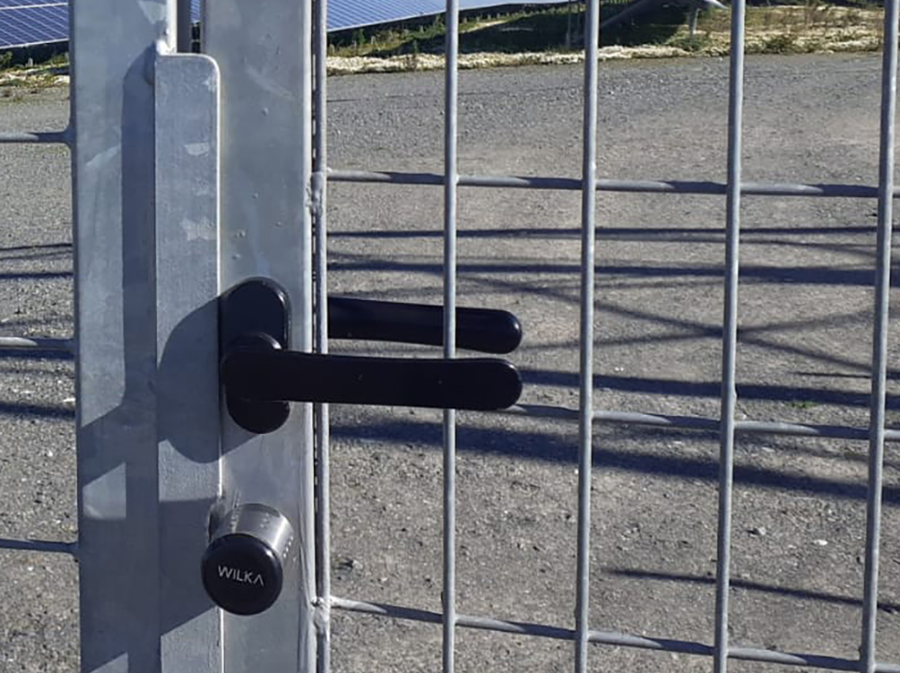 Detailweergave van de elektronische sluitcilinder WILKA easy op een metalen hekwerkpoort