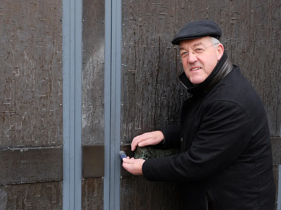 Pastoor Herbert Werth voor de kerkdeur